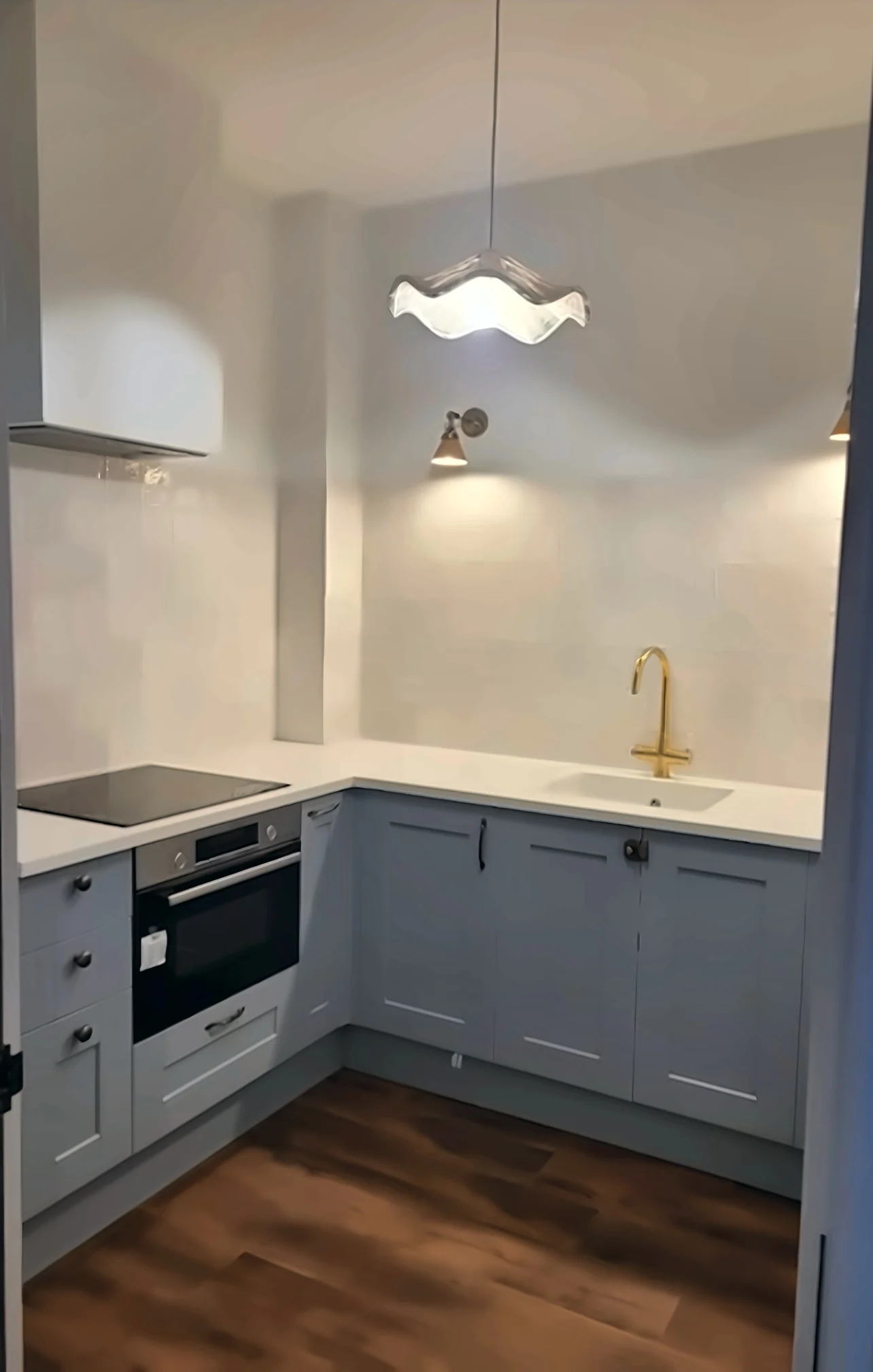 Completed Yadani compact L-shaped kitchen in soft blue Shaker cabinetry