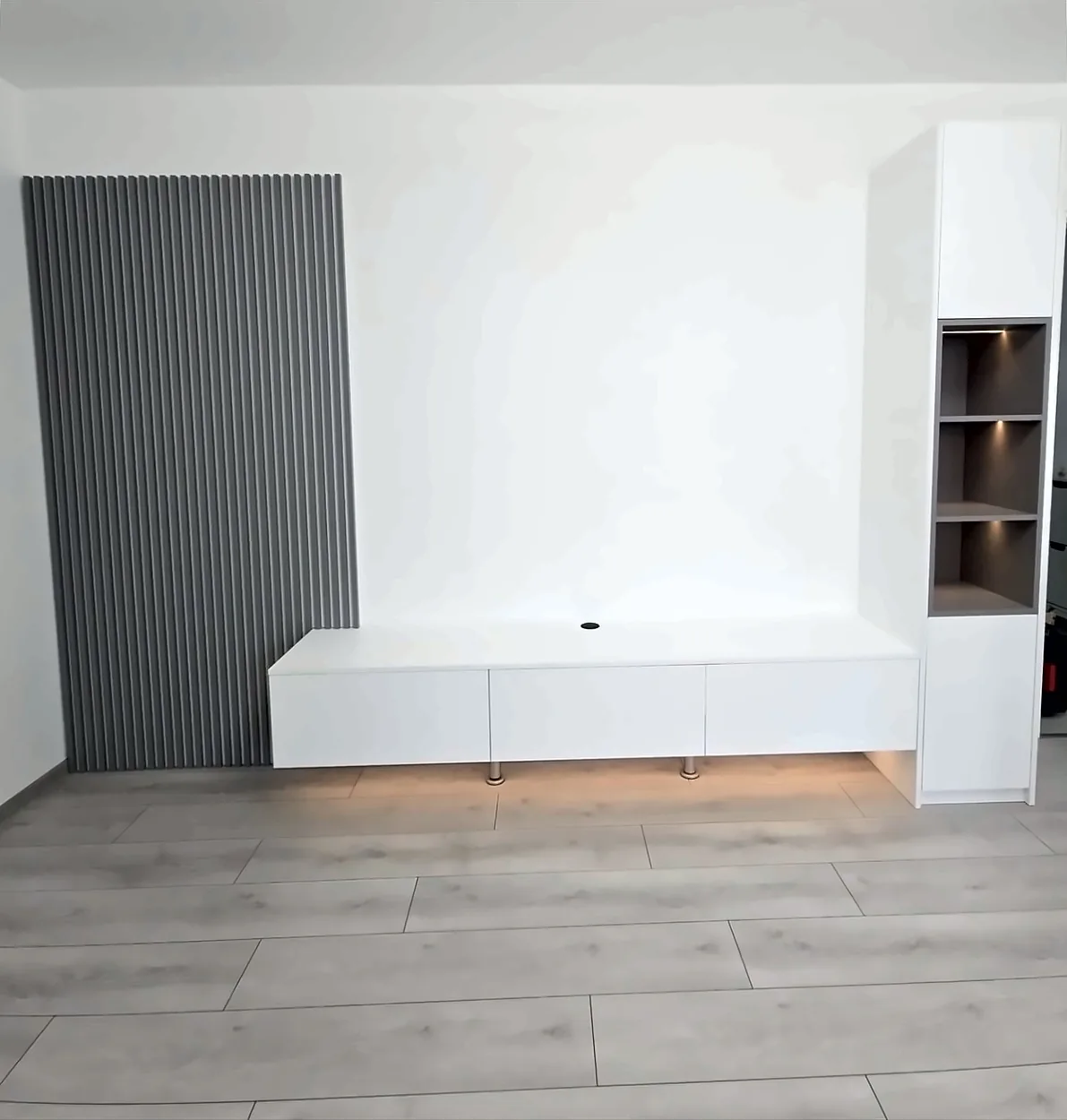 Completed Yadani floating white TV unit with a grey slatted panel and lit display tower